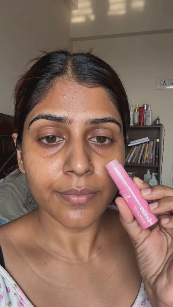 Indian woman demonstrates pink Erilas balm stick in bedroom, applies and pats in