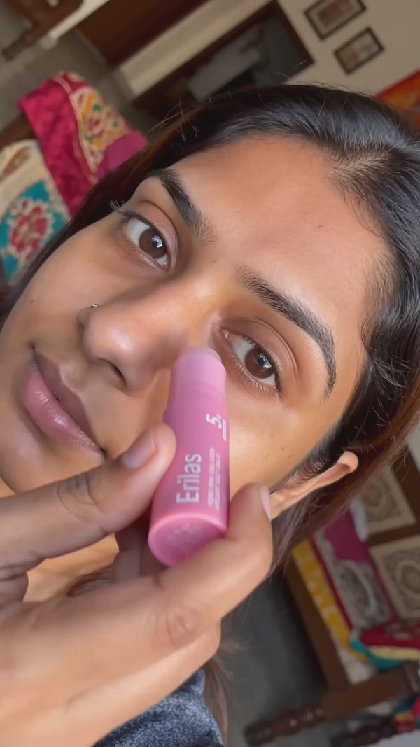 Indian woman selfie applying pink Erilas RoseVeil PDRN collagen balm stick to cheek and smiling